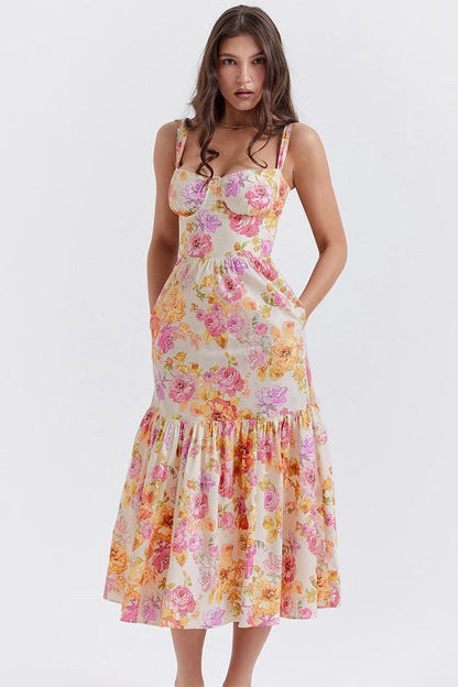 Woman in floral print sundress leaning on stone wall