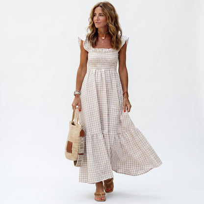 Beige - Woman wearing a gingham smocked maxi dress with flutter sleeves and a tiered skirt on a white background