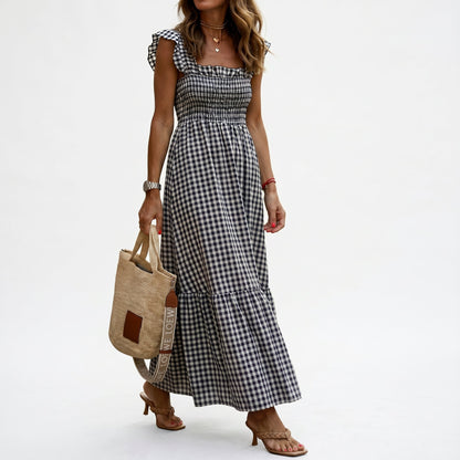 Black - Woman wearing a gingham smocked maxi dress with flutter sleeves and a tiered skirt on a white background