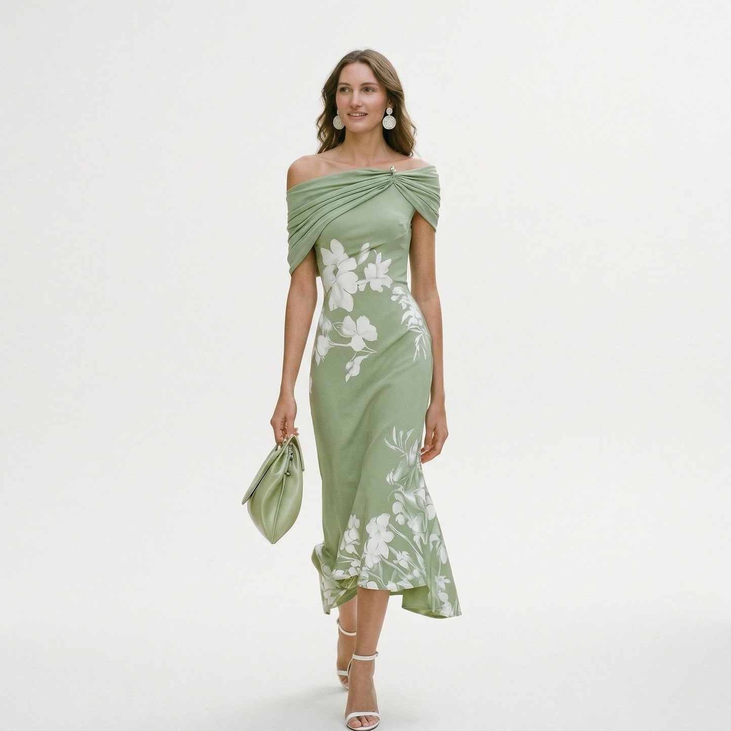 Green - Model wearing a green floral off-shoulder midi dress with a draped neckline and asymmetrical hem, holding a matching clutch.