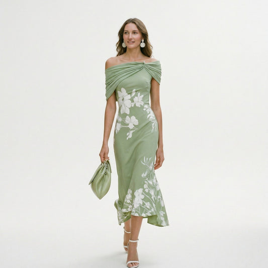 Green - Model wearing a green floral off-shoulder midi dress with a draped neckline and asymmetrical hem, holding a matching clutch.