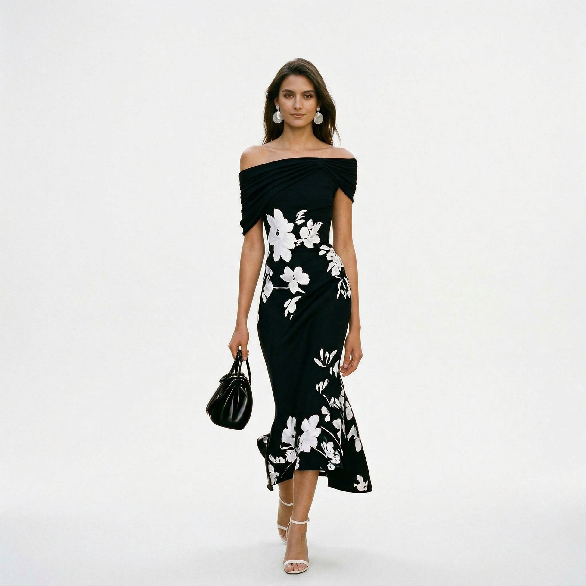 Black - Model wearing a green floral off-shoulder midi dress with a draped neckline and asymmetrical hem, holding a matching clutch.