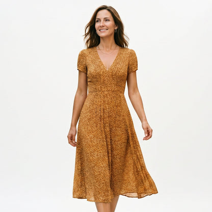 Yellow - Woman wearing a floral print midi dress featuring a V-neckline, short puff sleeves, and a flowing skirt.