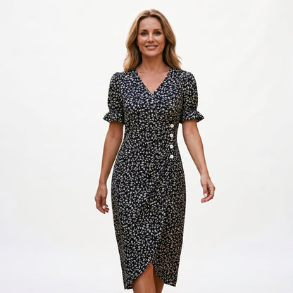 Black - Model wearing a floral V-neck midi dress with short ruffled sleeves and asymmetrical button detailing on a white background