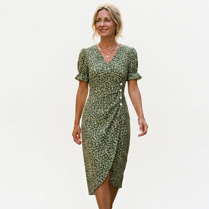 Green - Model wearing a floral V-neck midi dress with short ruffled sleeves and asymmetrical button detailing on a white background