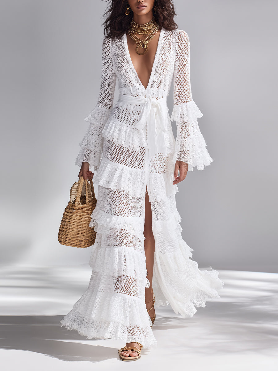 White - Woman wearing a crochet tiered maxi dress with long bell sleeves, a plunging neckline, and a waist tie, holding a woven basket bag