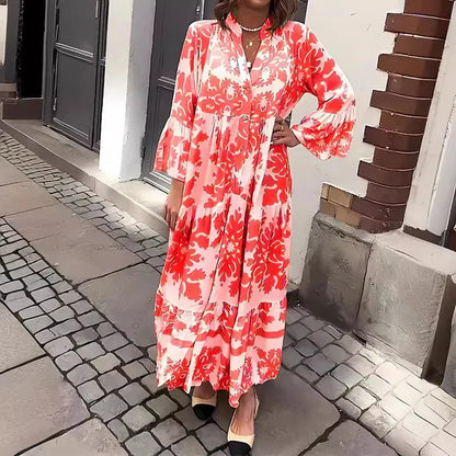 Red - A woman wearing a beige and cream baroque damask print maxi sundress with long bell sleeves, a split v-neckline, and a tiered skirt, standing on a cobblestone street.