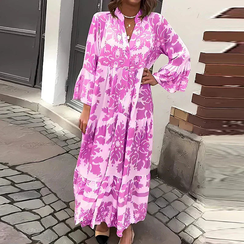 Purple - A woman wearing a beige and cream baroque damask print maxi sundress with long bell sleeves, a split v-neckline, and a tiered skirt, standing on a cobblestone street.