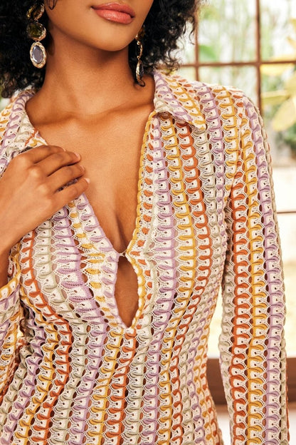 Woman in multicolored ribbed knit maxi dress with long sleeves and collared neckline