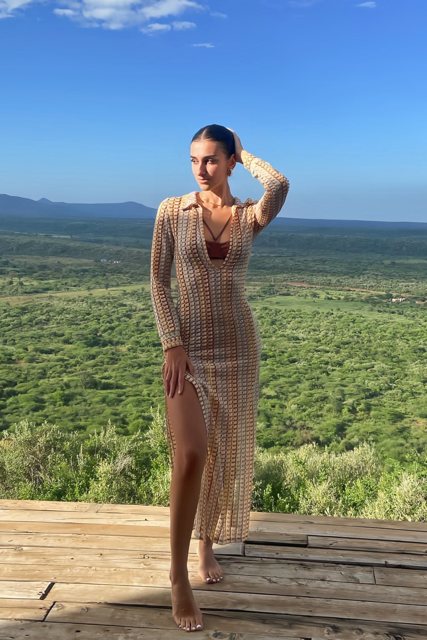 Woman in multicolored ribbed knit maxi dress with long sleeves and collared neckline
