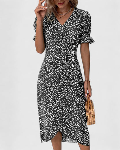 Black - A woman wearing a green midi dress with a white ditsy floral print, featuring short puff sleeves, a V-neckline, and decorative side buttons with a ruched wrap skirt.