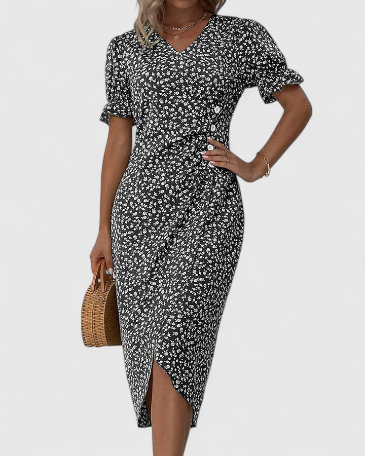Black - A woman wearing a green midi dress with a white ditsy floral print, featuring short puff sleeves, a V-neckline, and decorative side buttons with a ruched wrap skirt.