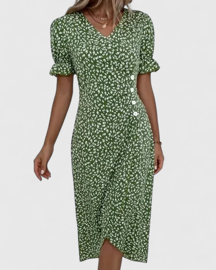 Green - A woman wearing a green midi dress with a white ditsy floral print, featuring short puff sleeves, a V-neckline, and decorative side buttons with a ruched wrap skirt.