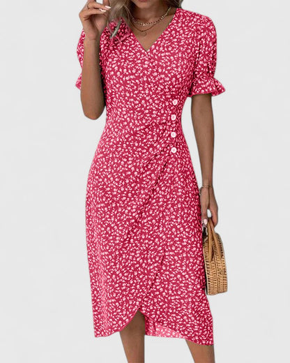 Red - A woman wearing a green midi dress with a white ditsy floral print, featuring short puff sleeves, a V-neckline, and decorative side buttons with a ruched wrap skirt.