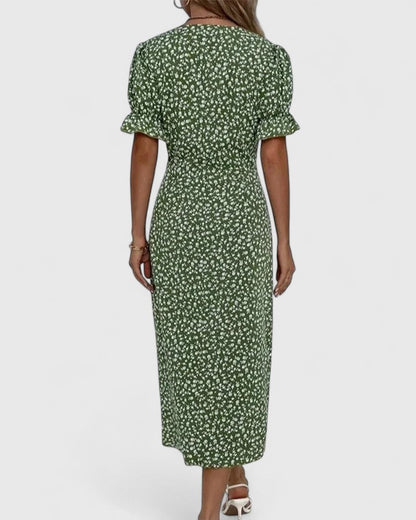 Red - A woman wearing a green midi dress with a white ditsy floral print, featuring short puff sleeves, a V-neckline, and decorative side buttons with a ruched wrap skirt.