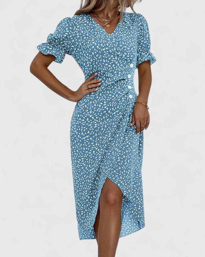 Red - A woman wearing a green midi dress with a white ditsy floral print, featuring short puff sleeves, a V-neckline, and decorative side buttons with a ruched wrap skirt.