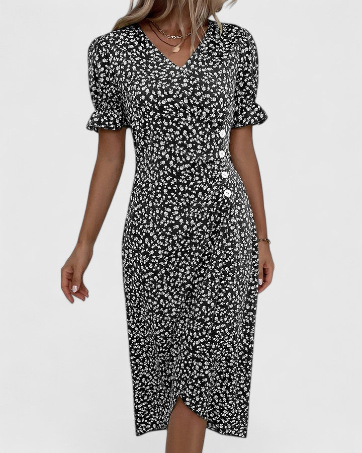 Blue - A woman wearing a green midi dress with a white ditsy floral print, featuring short puff sleeves, a V-neckline, and decorative side buttons with a ruched wrap skirt.