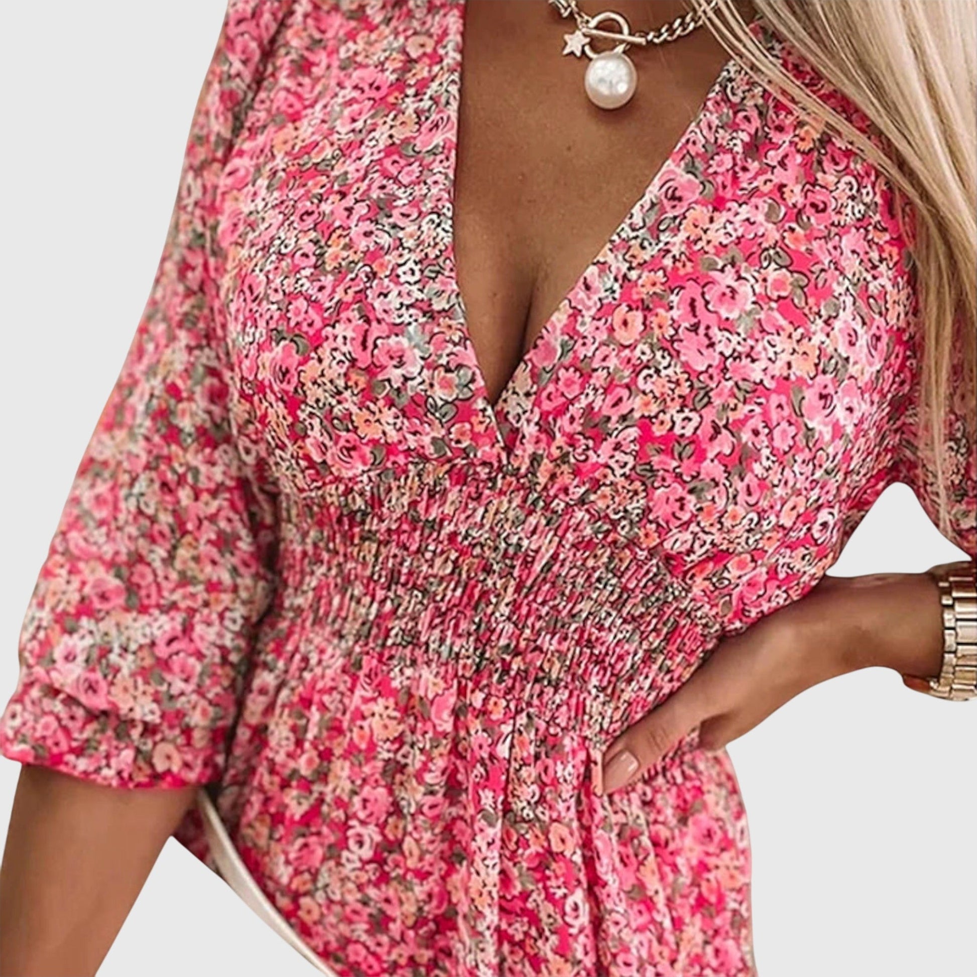 Pink - A woman wearing a blue and white ditsy floral print sundress with a v-neckline, three-quarter sleeves, a cinched waist, and a ruffled hem, holding a white quilted clutch bag.