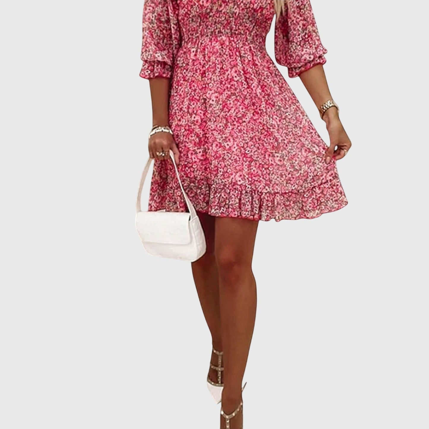 Pink - A woman wearing a blue and white ditsy floral print sundress with a v-neckline, three-quarter sleeves, a cinched waist, and a ruffled hem, holding a white quilted clutch bag.