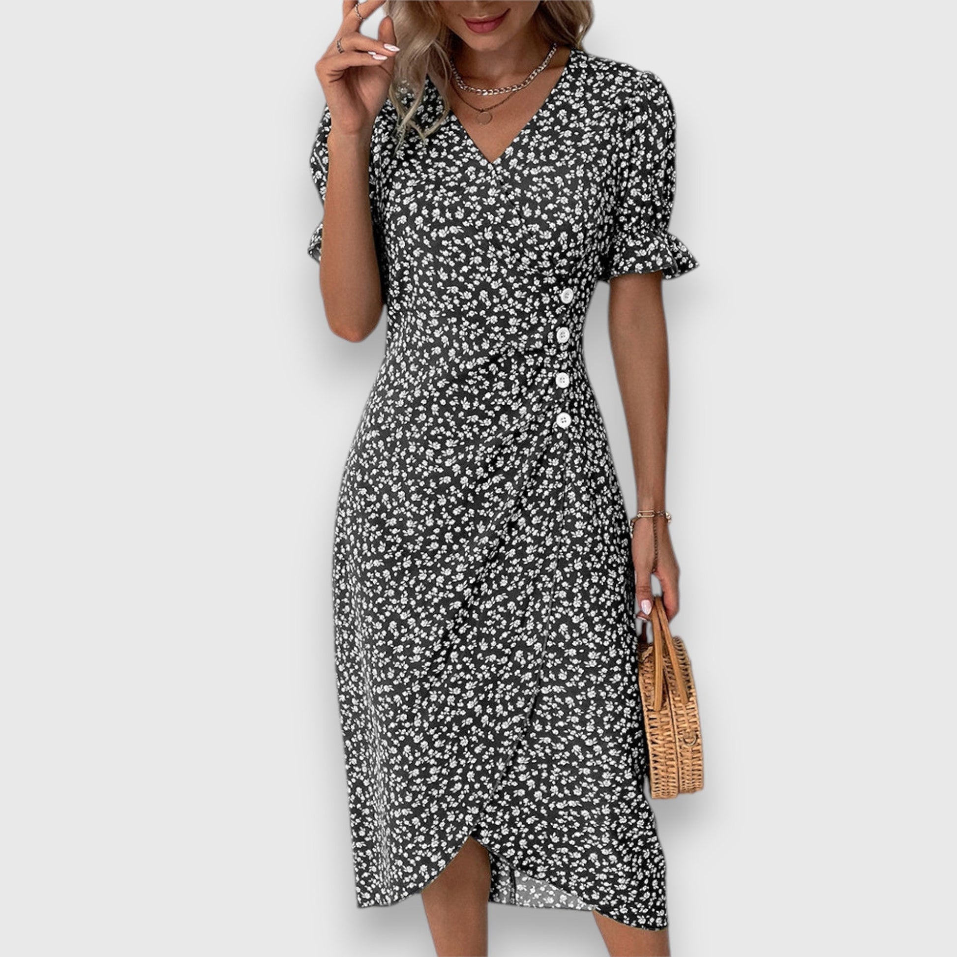 Black - A woman wearing a light blue midi sundress with a white ditsy floral print, featuring puff sleeves, a V-neckline, and an asymmetrical wrap skirt with button details.