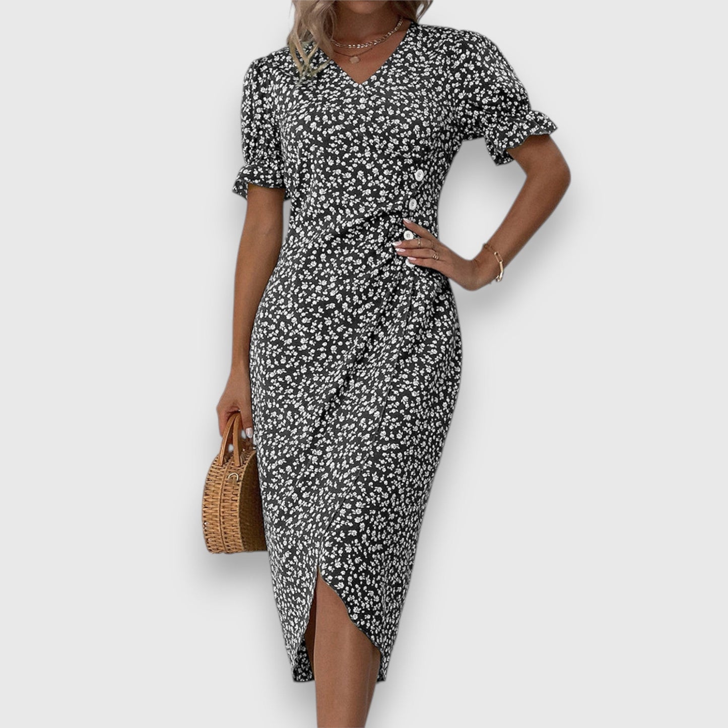 Black - A woman wearing a light blue midi sundress with a white ditsy floral print, featuring puff sleeves, a V-neckline, and an asymmetrical wrap skirt with button details.
