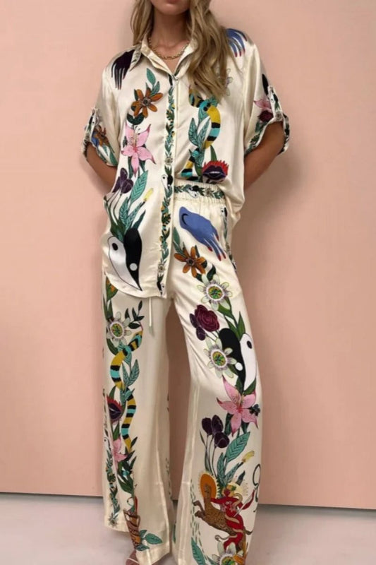 Woman wearing ivory satin pajama set with floral and yin yang print