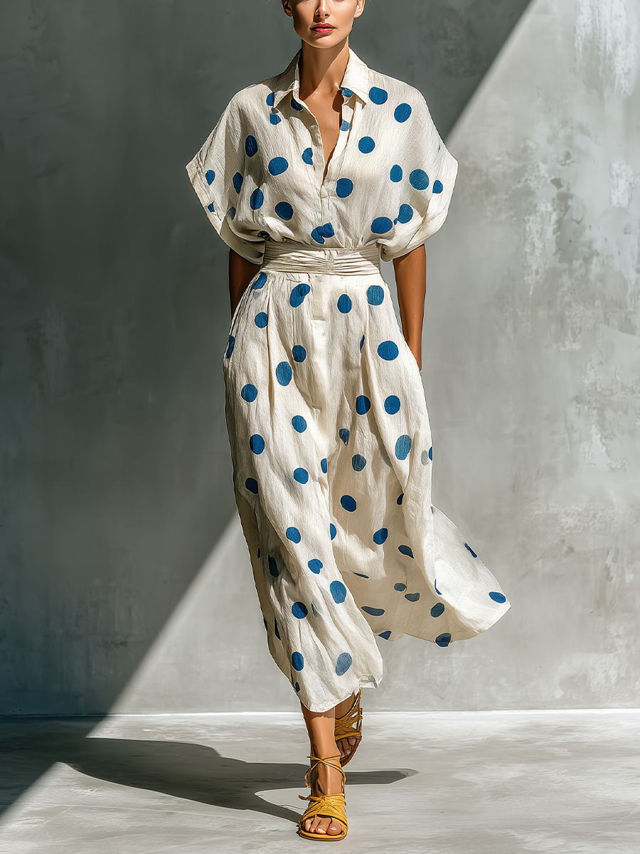 Off-White - Woman walking in a woven polka dot maxi dress with a collared neckline, dolman sleeves, and a wide ruched waistband.