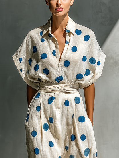 Off-White - Woman walking in a woven polka dot maxi dress with a collared neckline, dolman sleeves, and a wide ruched waistband.