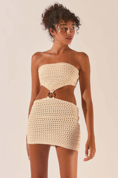 Woman wearing cream crocheted mini dress with cutout waist detail