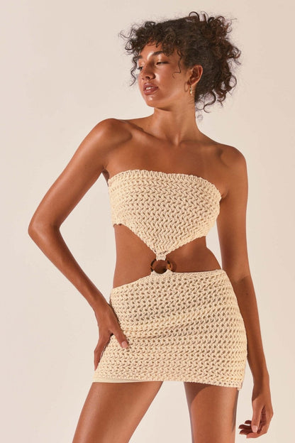 Woman wearing cream crocheted mini dress with cutout waist detail