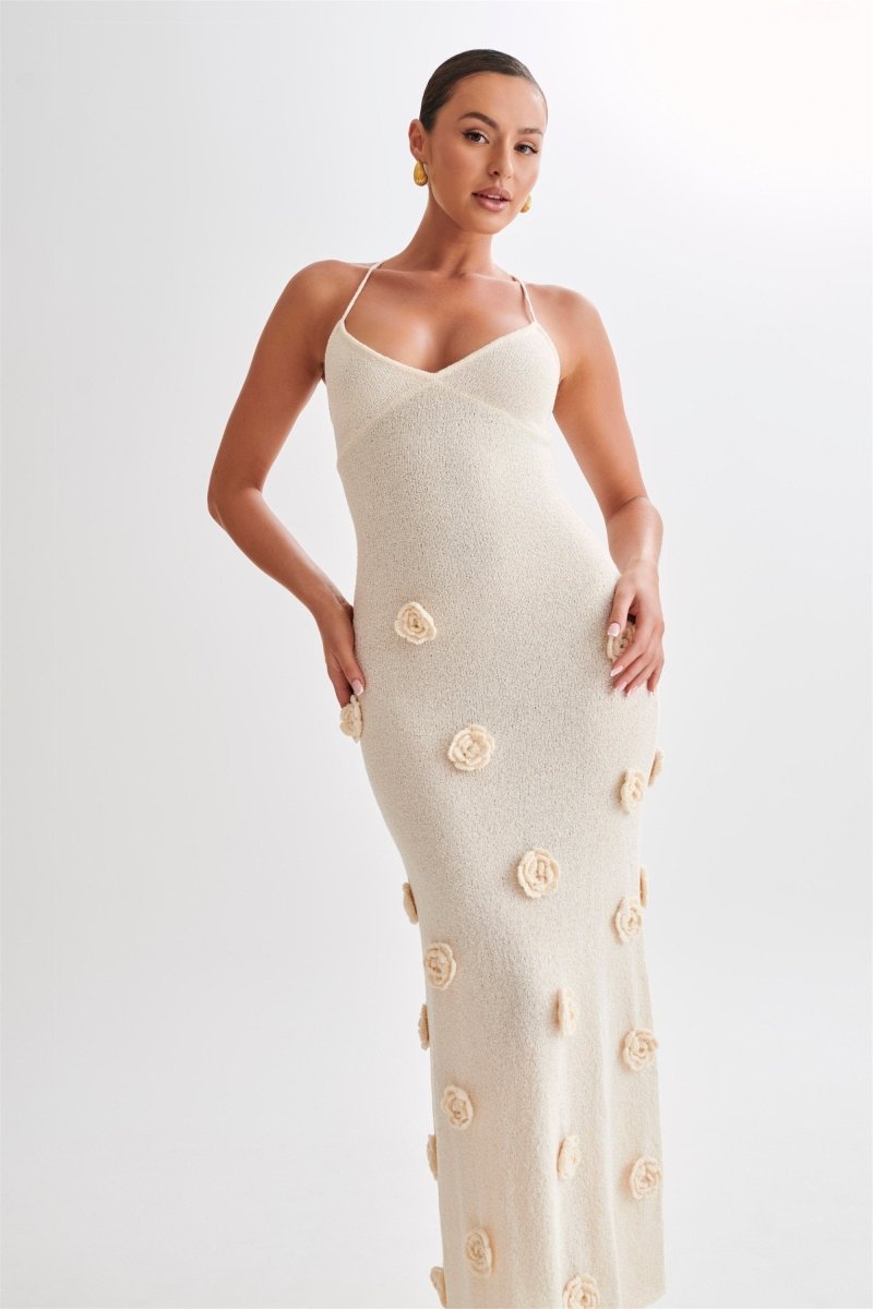 Woman wearing ivory knit maxi dress with floral appliqués