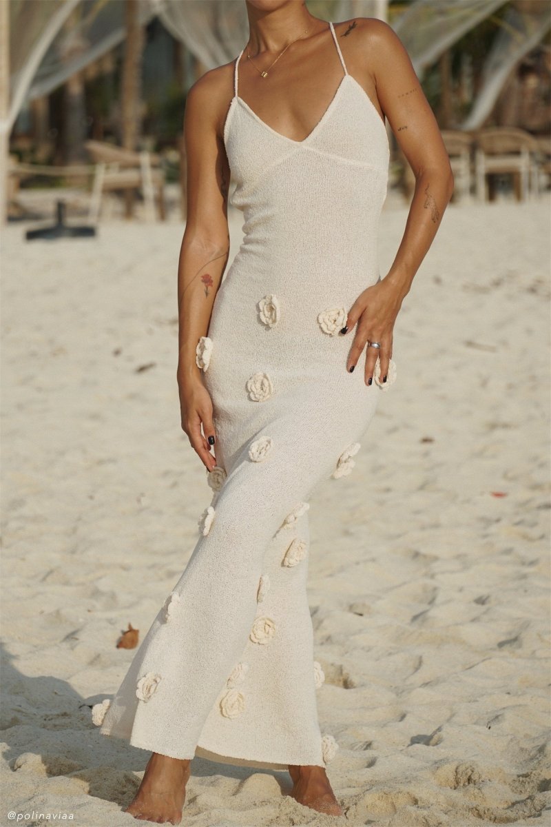 Woman wearing ivory knit maxi dress with floral appliqués