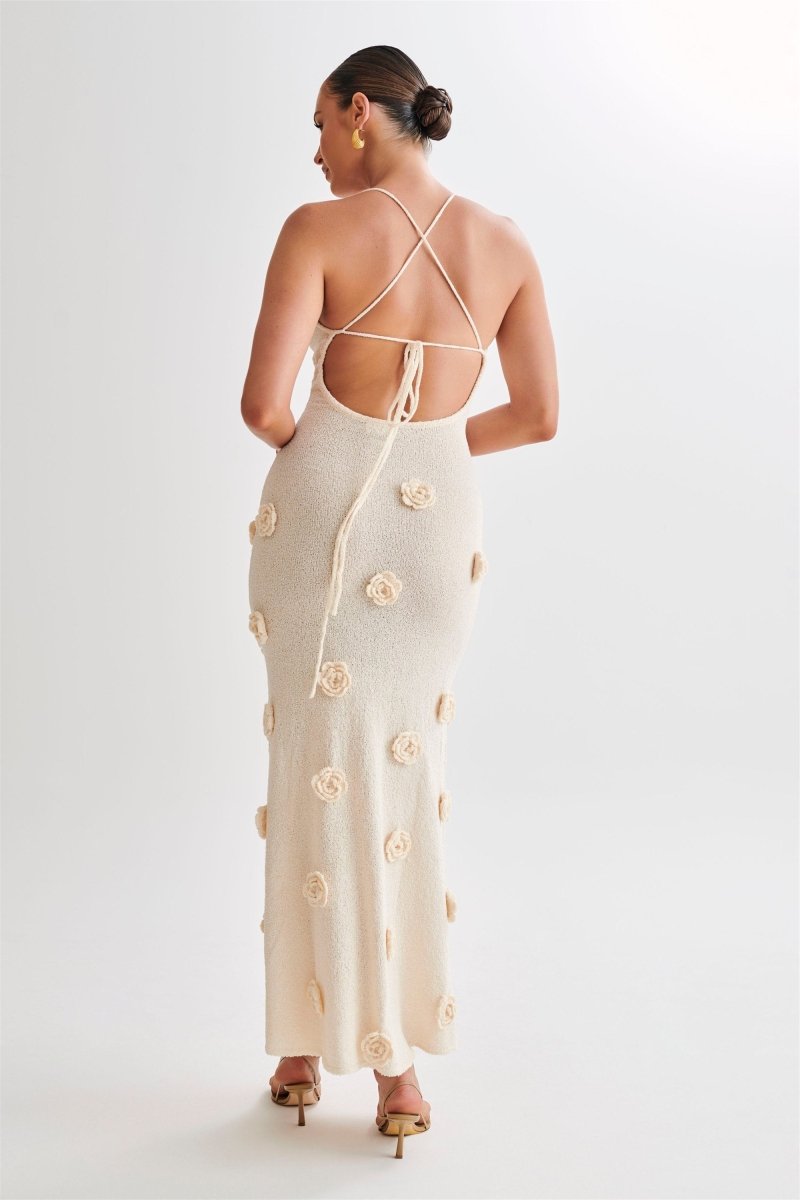 Woman wearing ivory knit maxi dress with floral appliqués