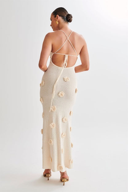 Woman wearing ivory knit maxi dress with floral appliqués