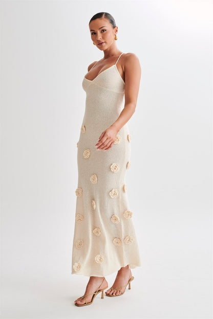 Woman wearing ivory knit maxi dress with floral appliqués
