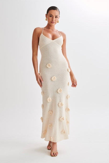 Woman wearing ivory knit maxi dress with floral appliqués