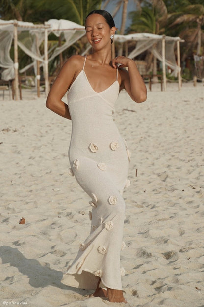 Woman wearing ivory knit maxi dress with floral appliqués