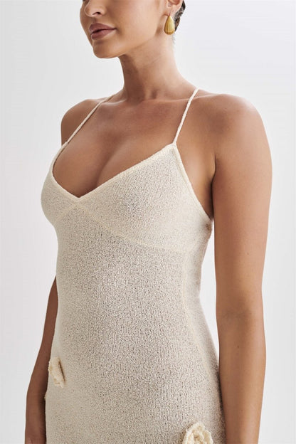 Woman wearing ivory knit maxi dress with floral appliqués