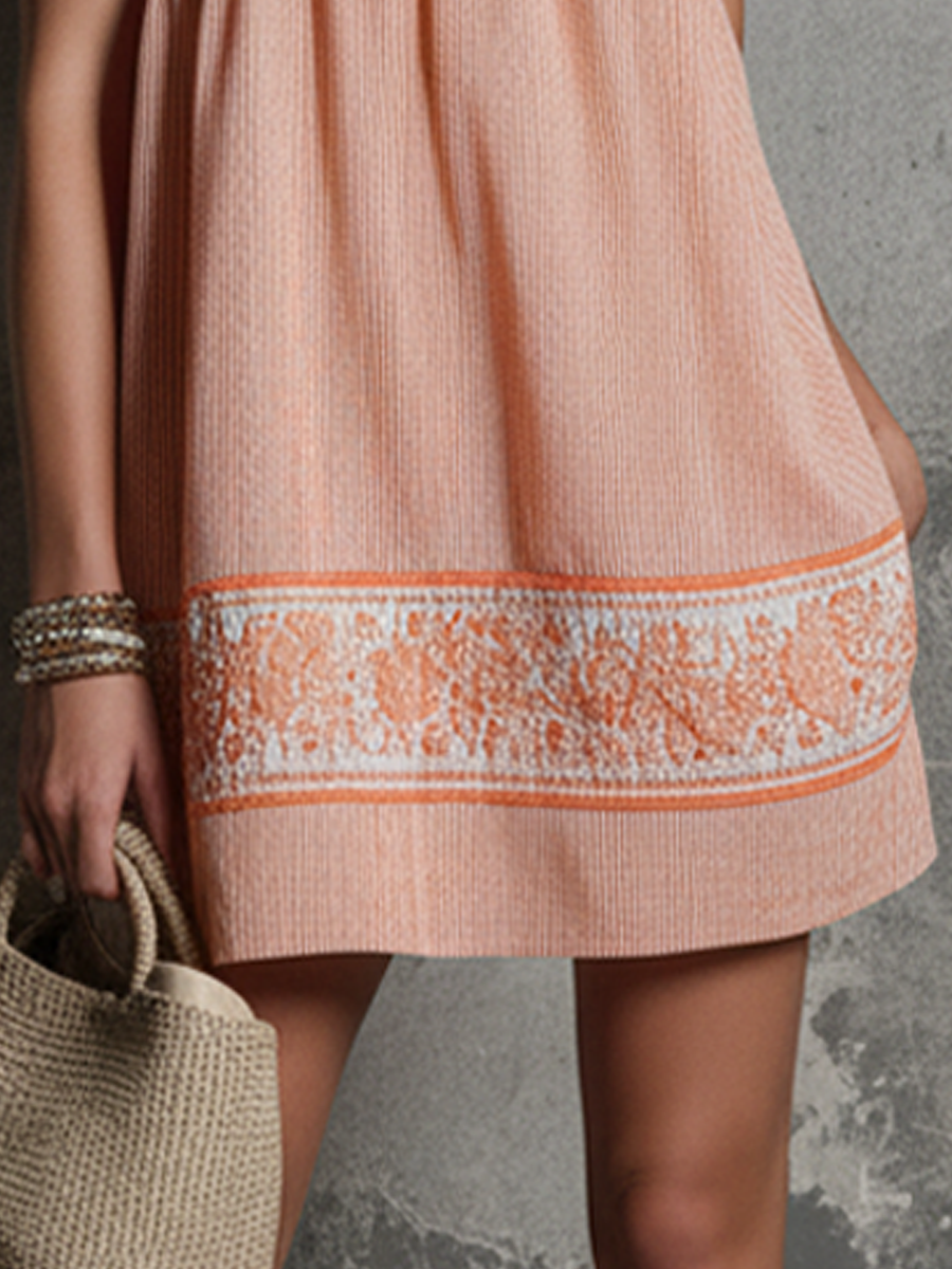 Orange - Model wearing a strapless boho mini dress with embroidered bodice and hem detailing, holding a woven bag.