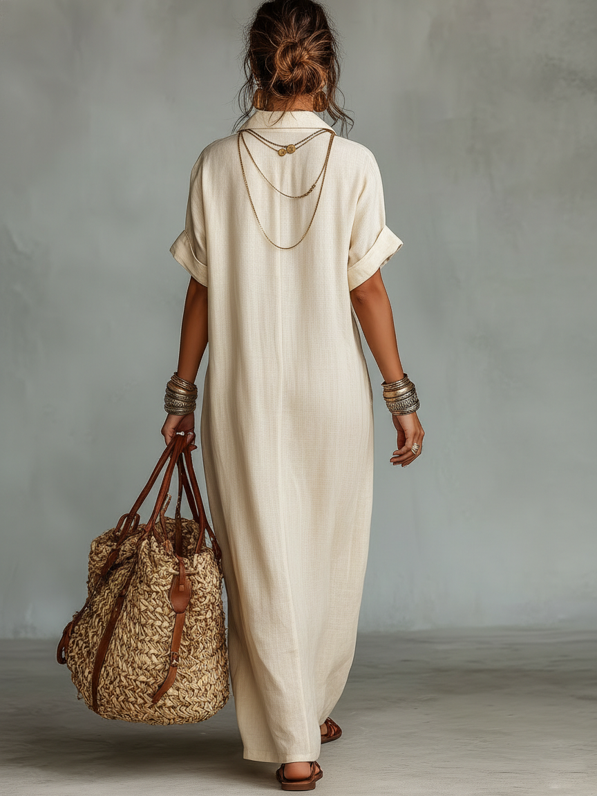Beige - Model wearing a relaxed fit woven maxi dress with a collared V-neckline, intricate front embroidery, and a single patch pocket, styled with a woven tote bag.