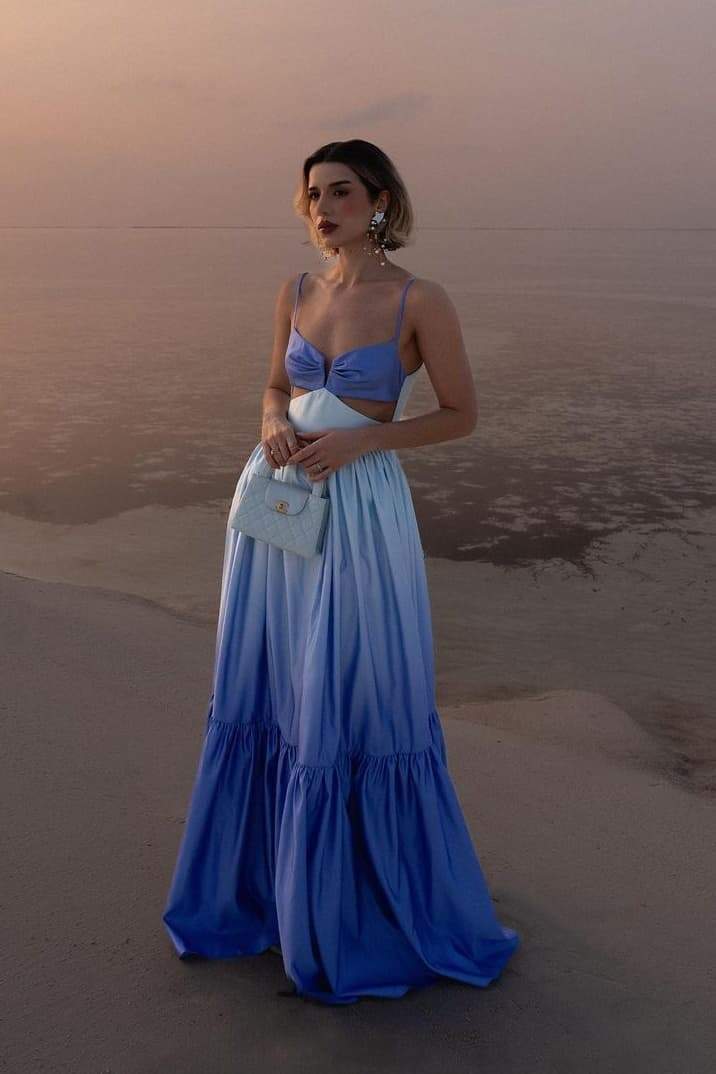Woman wearing blue ombre satin maxi dress with cutout waist