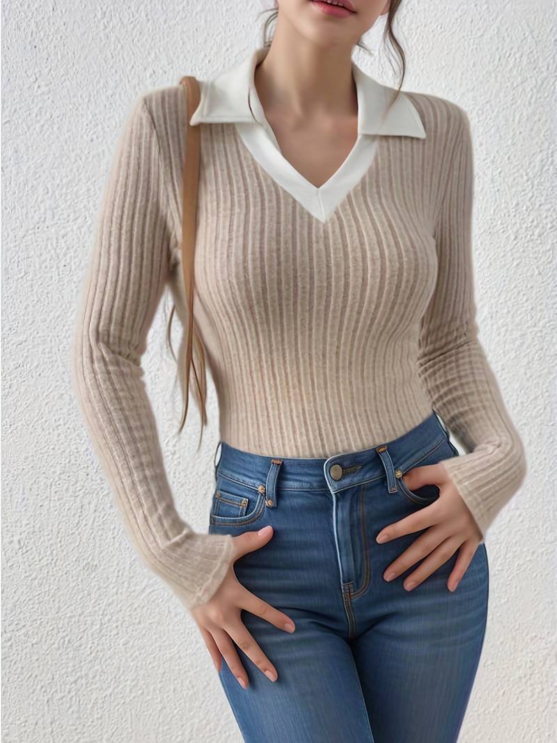 Woman wearing a light gray ribbed knit bodysuit with a white collar and black jeans.