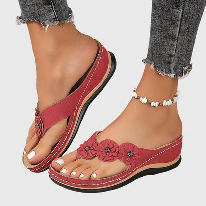 Red - Faux-suede slip-on wedge sandals featuring three floral appliques across the instep, contrast stitching details, and a contoured comfort footbed.