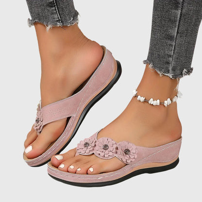 Pink - Faux-suede slip-on wedge sandals featuring three floral appliques across the instep, contrast stitching details, and a contoured comfort footbed.