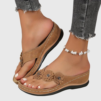 Dark Brown - Faux-suede slip-on wedge sandals featuring three floral appliques across the instep, contrast stitching details, and a contoured comfort footbed.