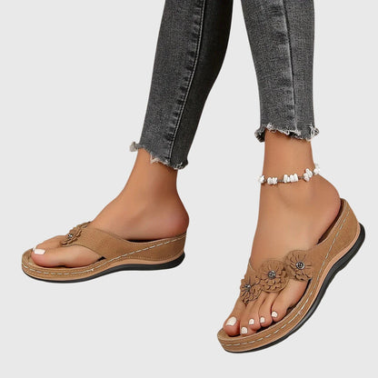 Black - Faux-suede slip-on wedge sandals featuring three floral appliques across the instep, contrast stitching details, and a contoured comfort footbed.