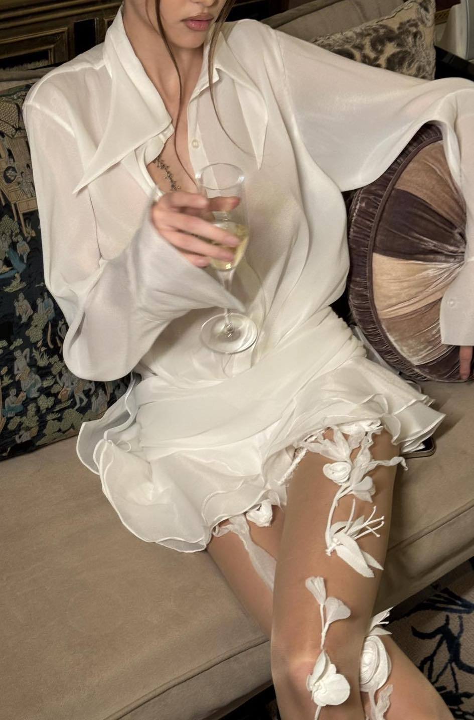 Woman in white sheer chiffon shirt dress with ruffles