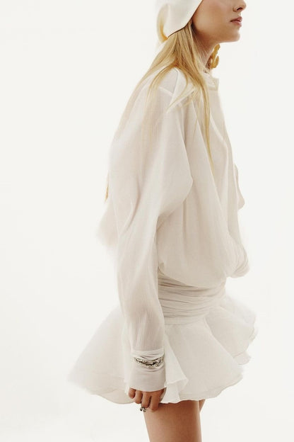 Woman in white sheer chiffon shirt dress with ruffles