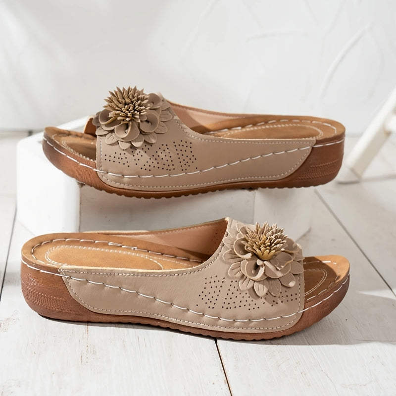 Brown - Women's slip-on wedge sandals featuring a perforated upper with a 3D floral applique and contrast stitching.
