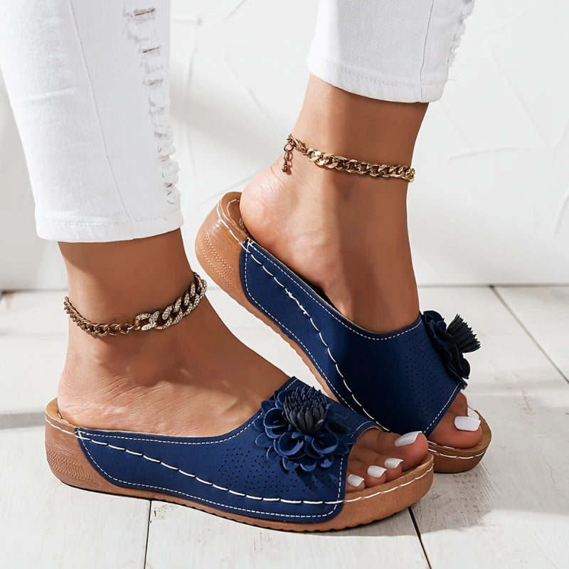 Blue - Women's slip-on wedge sandals featuring a perforated upper with a 3D floral applique and contrast stitching.